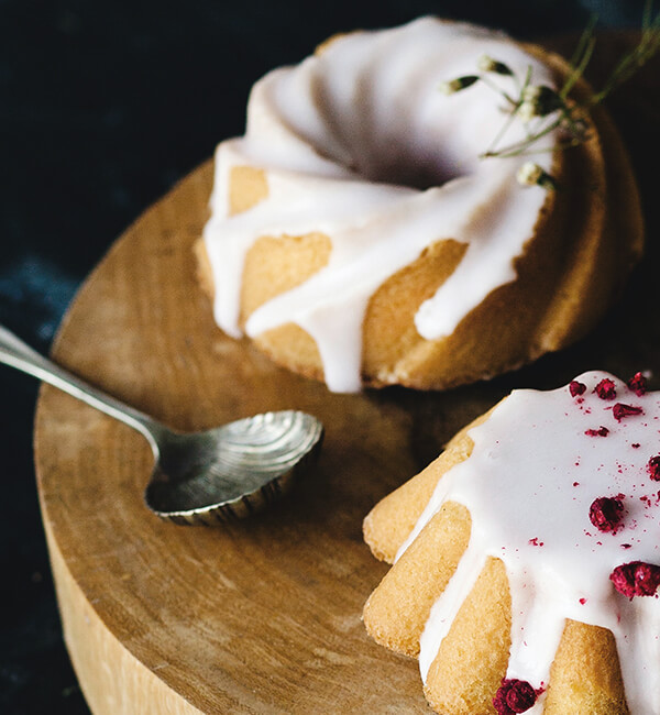 Iced bundt cakes on a wooden board