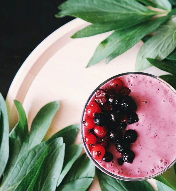 A berry smoothie topped with fresh fruit