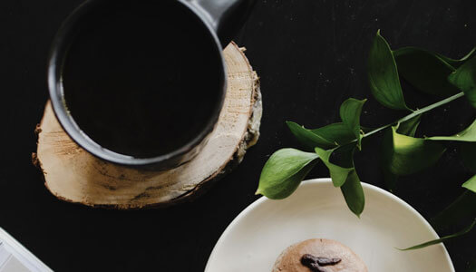A mug of coffee beside a pastry